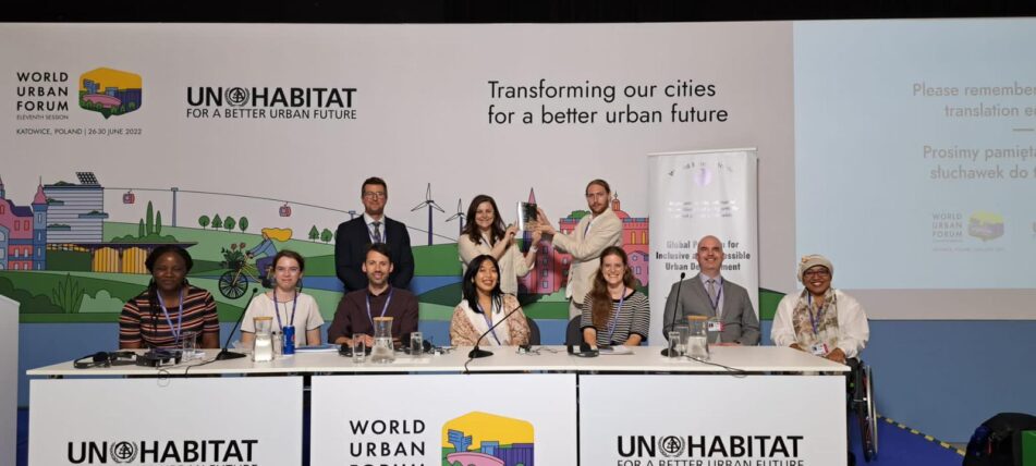 A group of speakers sat behind a desk after a panel discussion