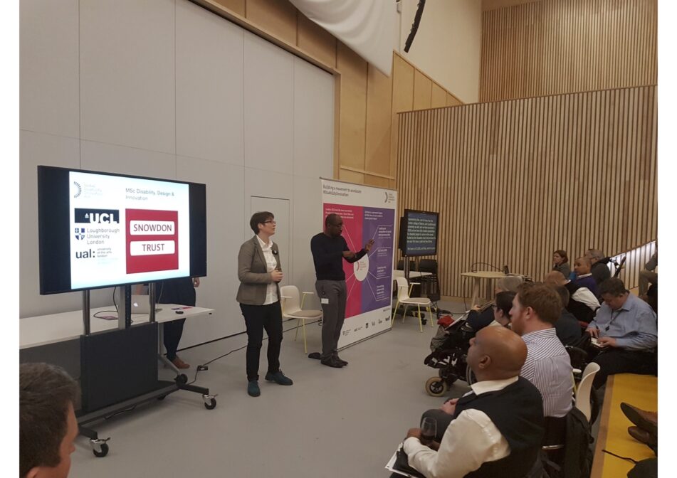 Cathy Holloway, Academic Director at the GDI Hub presents (with an interpreter) during Town Hall Meeting