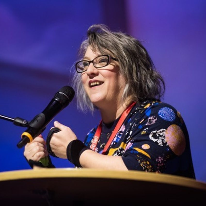 Close up picture picture of Jo Verrent delivering a Speech against a dark purple background