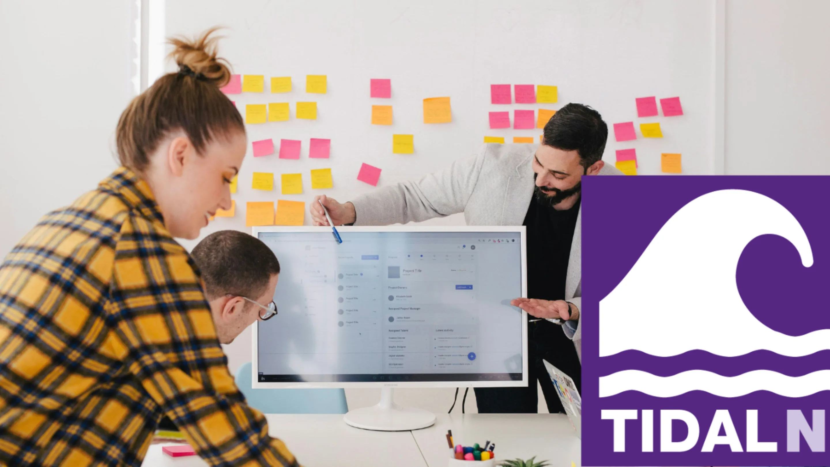 People working as a group on a desk. Tidal logo in right bottom corner