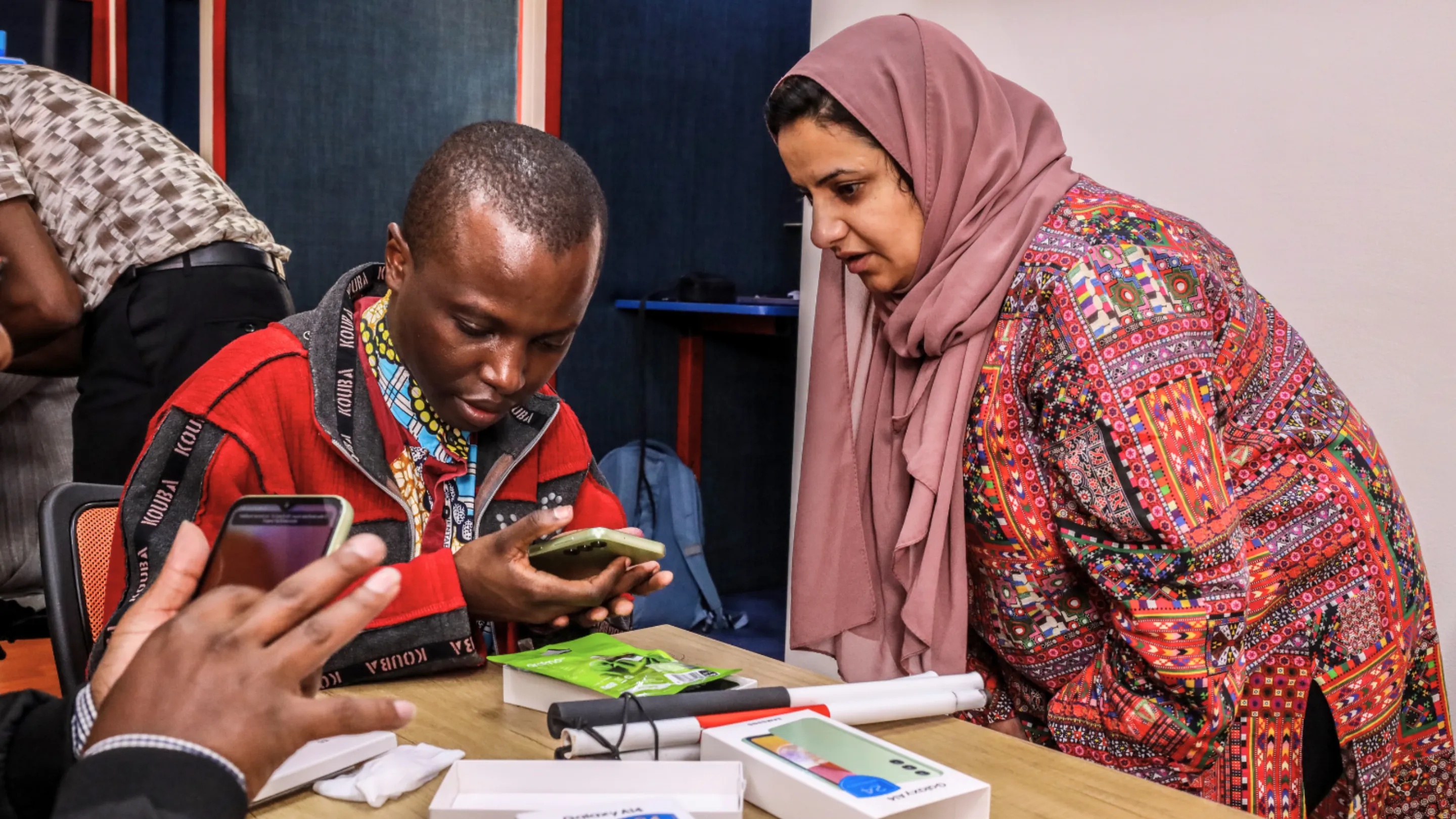 Two people are looking at a mobile phone