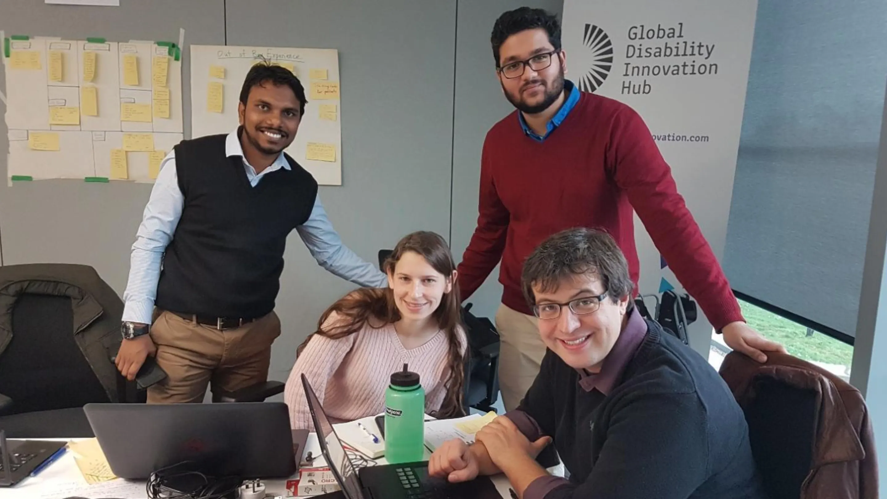 photo of team smiling next to a GDI hub banner
