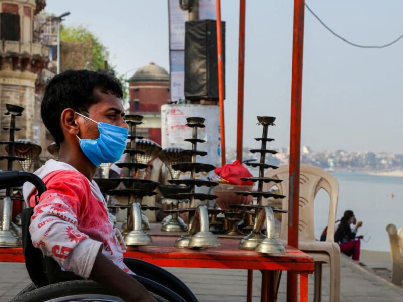 A man in a wheelchair looking out over a river in india