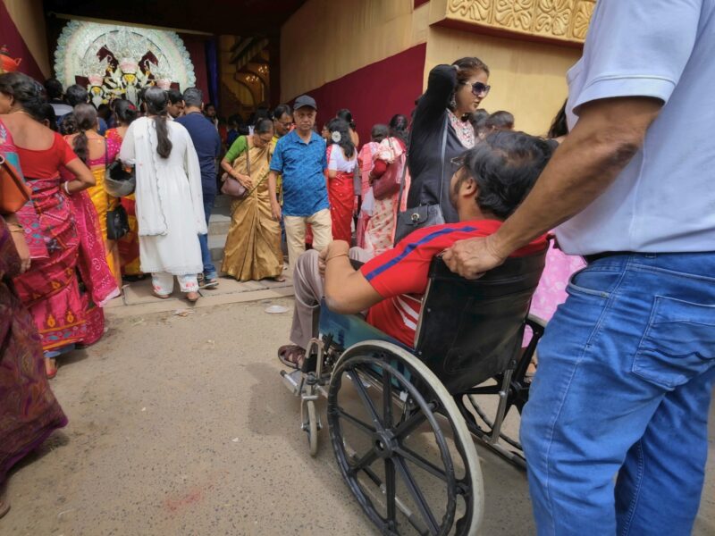 Person in wheelchair approaching place of worship in India