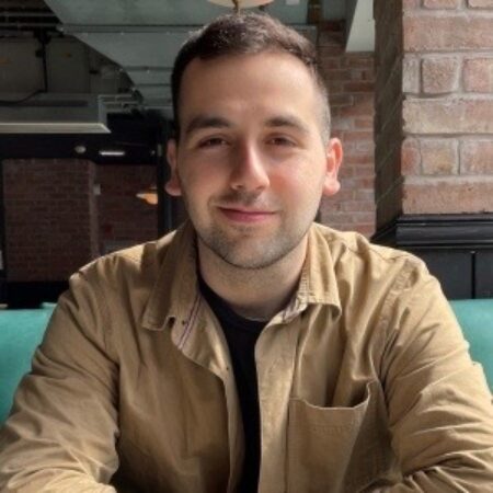 Andreas is shown from the chest up smiling