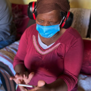 A woman wearing headphones using a smartphone