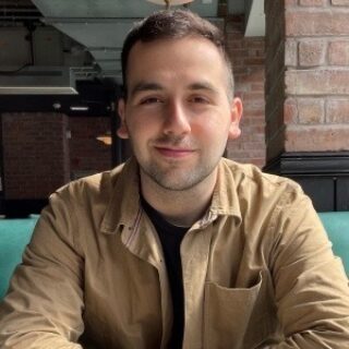 Andreas is shown from the chest up smiling