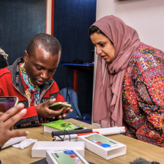 Two people are looking at a mobile phone