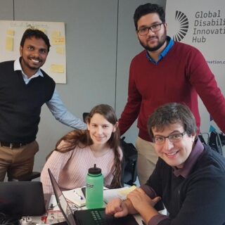 photo of team smiling next to a GDI hub banner