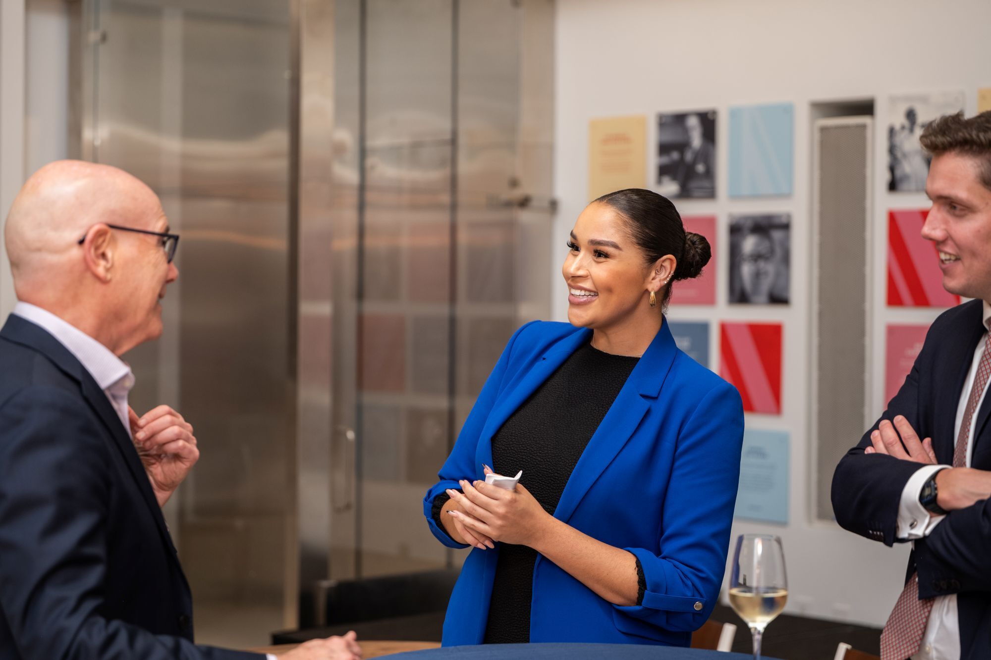 Reception discussions and networking, with three attendees in conversation